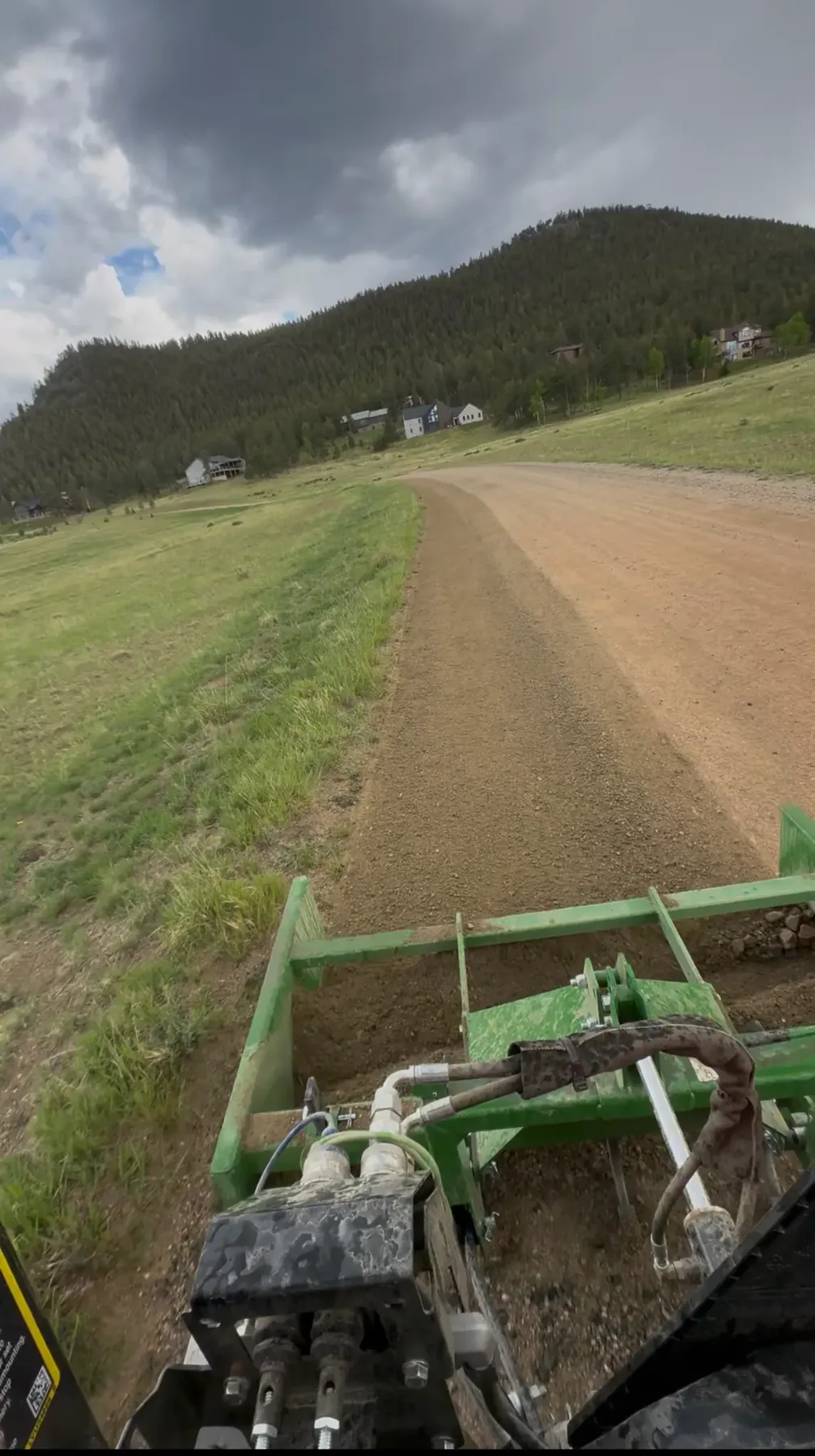 Tractor grading a dirt road through a Colorado mountain property