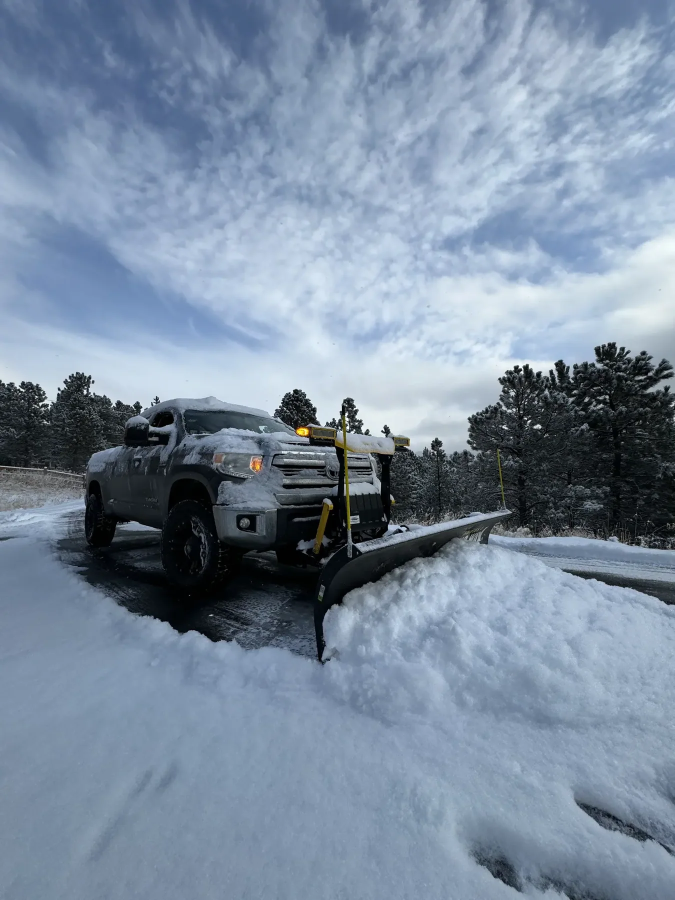 Snowplow truck clearing a Colorado mountain road
